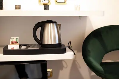 a tea kettle sitting on a desk next to a chair at Hotel Cinquantatre in Rome