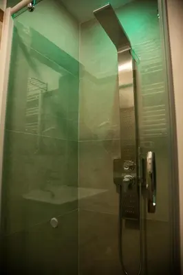 a shower with a glass door with a sink at Hotel Cinquantatre in Rome