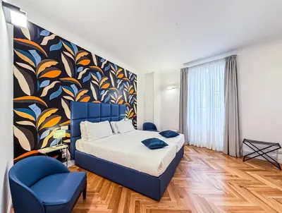 a bedroom with a bed and a blue chair at Albergo Abruzzi in Rome