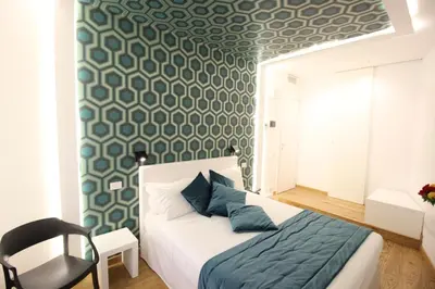 a bedroom with a bed with a blue and white patterned wall at Albergo Abruzzi in Rome