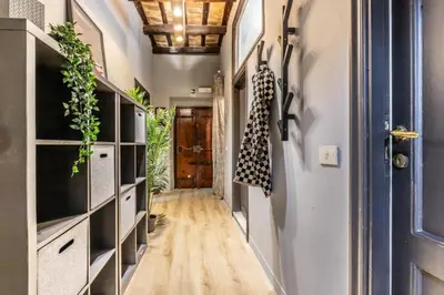 a hallway with a blue door and a hallway with plants at Flatinrome Trastevere Complex in Rome