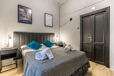 a bedroom with a large bed with blue pillows at Flatinrome Trastevere Complex in Rome