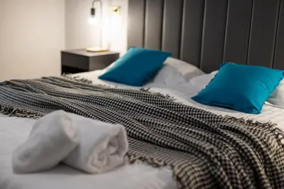 a bed with two blue pillows on top of it at Flatinrome Trastevere Complex in Rome