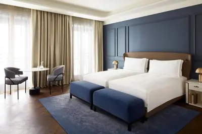 a bedroom with a large bed and a table and chairs at InterContinental Rome Ambasciatori Palace by IHG in Rome