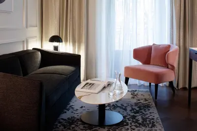 a living room with a couch and a chair and a table at InterContinental Rome Ambasciatori Palace by IHG in Rome
