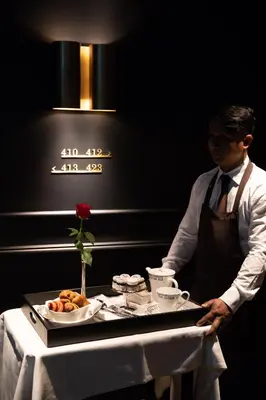 a man standing in front of a table with a tray of food at InterContinental Rome Ambasciatori Palace by IHG in Rome