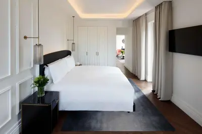 a bedroom with a white bed and a tv at InterContinental Rome Ambasciatori Palace by IHG in Rome