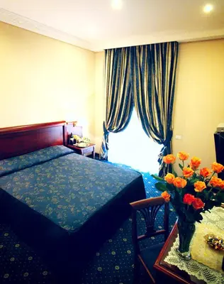 a hotel room with a bed and a table with flowers at Hotel Artorius in Rome
