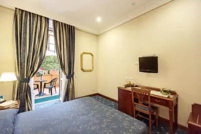 a hotel room with a bed and a desk and a television at Hotel Artorius in Rome