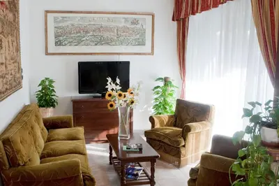 a living room with two chairs and a vase of flowers at Hotel Antico Acquedotto in Rome