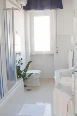 a white bathroom with a toilet and a sink at Hotel Antico Acquedotto in Rome
