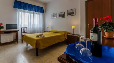 a living room with a bottle of wine and a bed at Hotel Antico Acquedotto in Rome