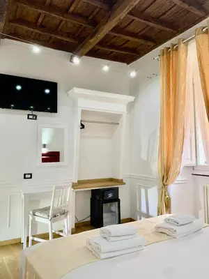 a white room with two beds and a television at Domus Ester in Rome