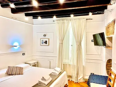a bedroom with two beds and a tv in it at Domus Ester in Rome
