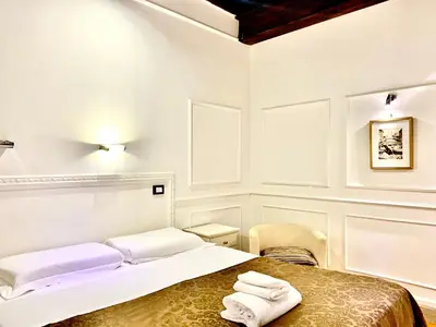 a white room with a bed with towels on it at Domus Ester in Rome