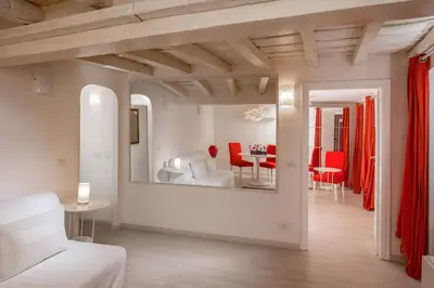 a living room with a white couch and red chairs at Boutique Hotel Campo de' Fiori in Rome