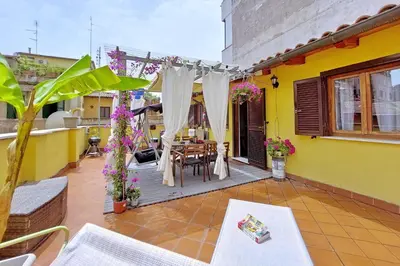 a patio with a table and chairs on a yellow house at Luxury Domus in Rome
