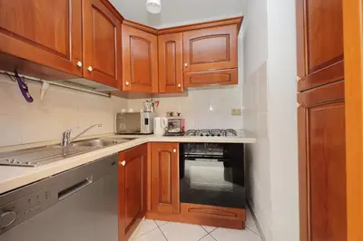 a small kitchen with wooden cabinets and a sink at Luxury Domus in Rome