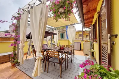 a patio with a table and chairs and an umbrella at Luxury Domus in Rome