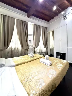 two beds in a bedroom with curtains at L'antica Locanda Dell'Orso in Rome