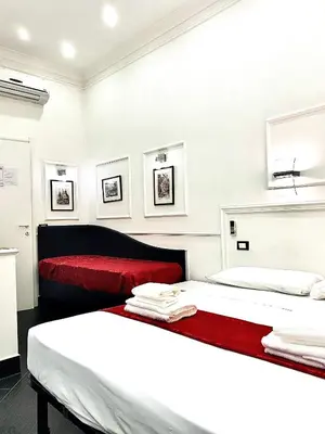 two beds in a room with two red beds at L'antica Locanda Dell'Orso in Rome