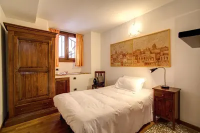 a bedroom with a white bed and a wooden door at Residenza Domizia in Rome