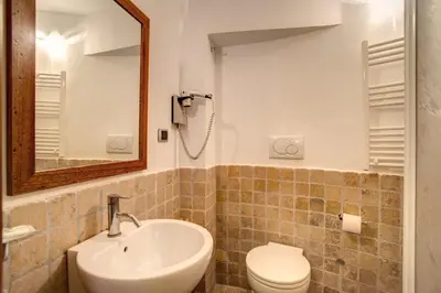 a bathroom with a sink and a toilet and a mirror at Residenza Domizia in Rome