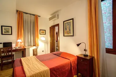 a bedroom with a bed and a desk and a lamp at Residenza Domizia in Rome