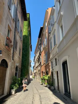 a woman walking down a street in an alley at Residenza Domizia in Rome
