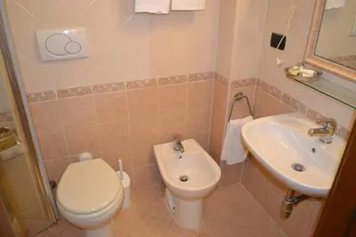 a bathroom with a toilet and a sink at Dipendenza Hotel Galileo in Rome