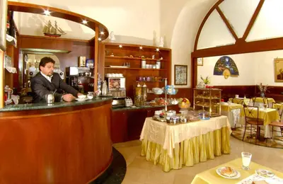 a man standing at a bar in a restaurant at Hotel Assisi in Rome