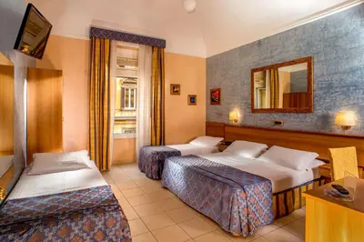 a hotel room with two beds and a mirror at Hotel Assisi in Rome