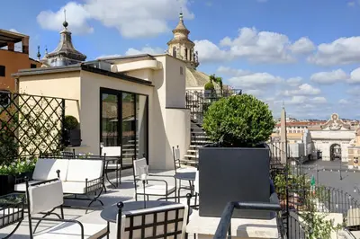 a patio with chairs and tables on top of a building at Palazzo Nainer in Rome
