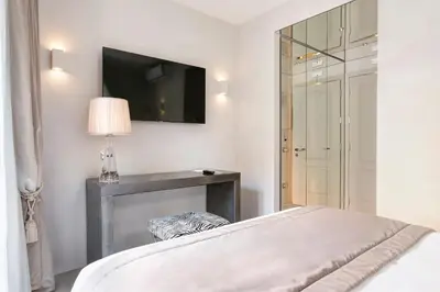a bedroom with a bed and a television on the wall at Palazzo Nainer in Rome