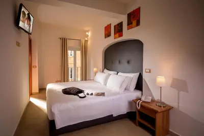 a bedroom with a large white bed and a table at Suite Artis Barberini in Rome