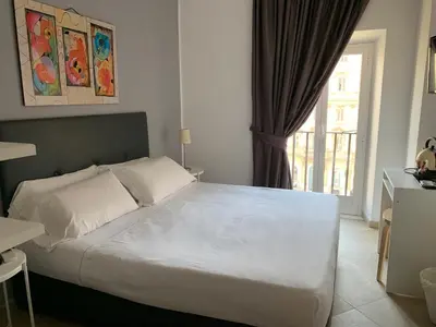 a bedroom with a large white bed with a window at Suite Artis Barberini in Rome