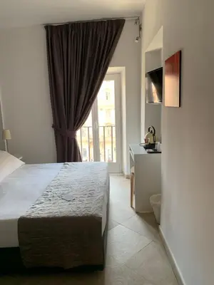 a bedroom with a large bed and a window at Suite Artis Barberini in Rome