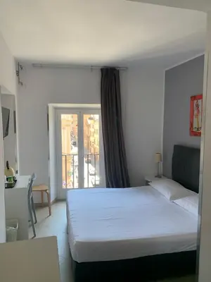 a bedroom with a white bed and a window at Suite Artis Barberini in Rome