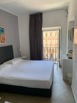 a bedroom with a large bed and a large window at Suite Artis Barberini in Rome