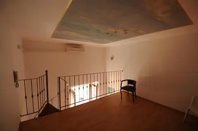 a room with a staircase with a chair and a ceiling at Casa Vacanze Colosseo da Fernando no elevator in Rome