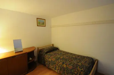a small bedroom with a bed and a dresser at Casa Vacanze Colosseo da Fernando no elevator in Rome