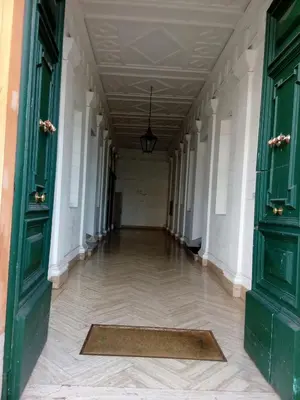 an empty hallway in a building with green doors at Casa Vacanze Colosseo da Fernando no elevator in Rome
