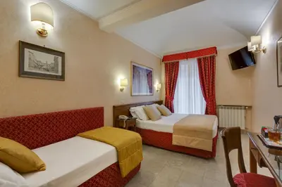 a hotel room with two beds and a table at Hotel Silla in Rome