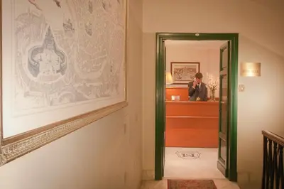 a man standing in a hallway with a picture on the wall at Hotel Silla in Rome