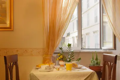 a table with a white table cloth and a window at Hotel Silla in Rome