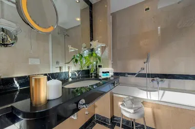 a hotel room with a bathroom and a bedroom at Cardinal Hotel St. Peter in Rome