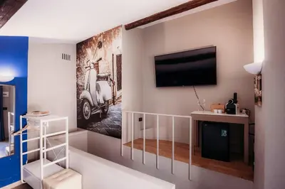 a room with a tv and a scooter painting on the wall at Hotel Domus Tiberina in Rome