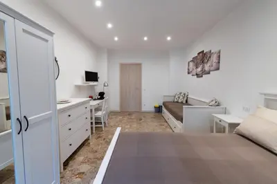 a bedroom with a bed and a desk and a couch at Casa Rosa Beige e Blu in Rome