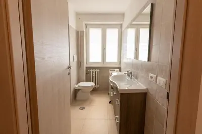 a bathroom with a toilet and a sink and a mirror at Casa Rosa Beige e Blu in Rome