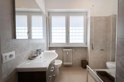 a bathroom with a sink and a toilet and a mirror at Casa Rosa Beige e Blu in Rome